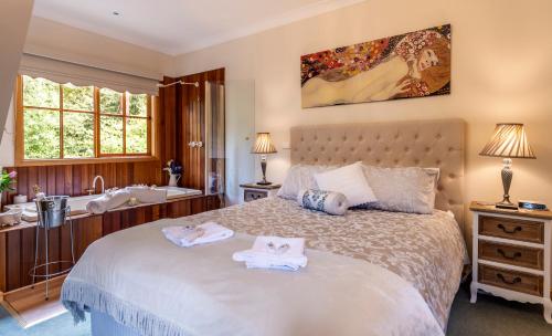 a bedroom with a bed and a tub and a sink at Mountain Lodge in Mount Dandenong