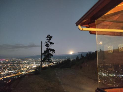a view of a city at night from a building at Pumamaki EcoLodge Glamping in Quito