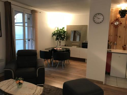 un salon avec une table et une horloge murale dans l'établissement Disney cosy lounge, à Serris