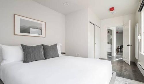 a white bedroom with a large white bed in a room at Reside Seattle Downtown, a Wyndham Residence in Seattle