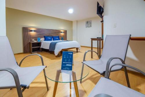 a hotel room with a bed and two chairs at Premier Tambo in Arequipa
