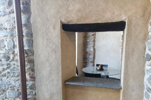 Habitación con mesa y pared de piedra. en [Medioevo con giardino] Lake Varese wifi Netflix, en Gavirate
