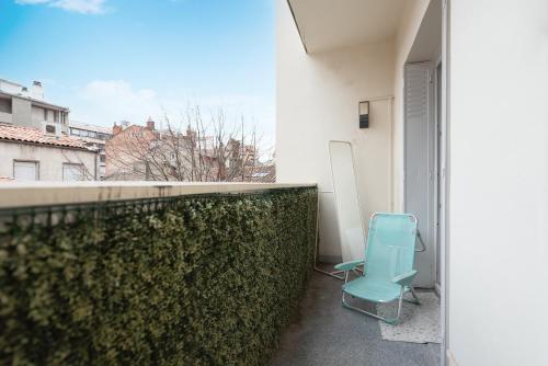 a blue chair sitting on the balcony of a building at L élégance toulousaine avec garage in Toulouse
