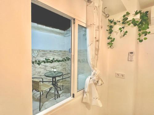 a window with a table and a view of the ocean at JARA HOME Malaga Centro in Málaga