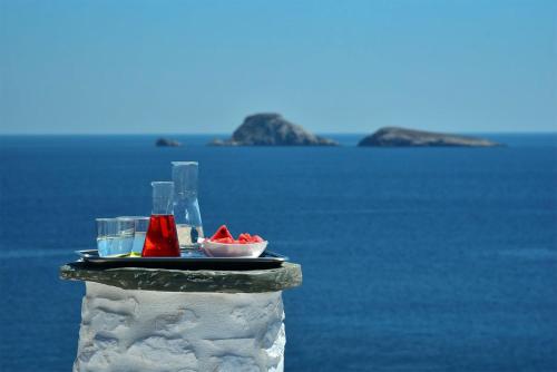a table with a plate of food next to the water at Onar Suites & Villas in Karavostasi