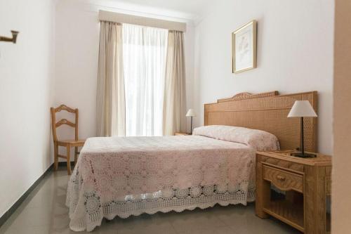 um quarto com uma cama, uma mesa e uma janela em Casa Clara, Caminito de Rey em Valle de Abdalagís