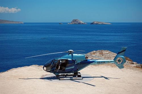 a blue helicopter sitting on top of a beach at Onar Suites & Villas in Karavostasi