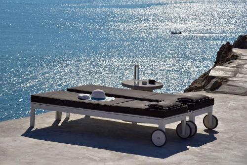 a bed on a table next to the water at Onar Suites & Villas in Karavostasi