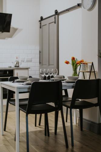 a dining room with a table with chairs and glasses at BlueSeaView Apartment with fabulous sea views in Newcastle