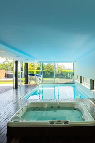 a large swimming pool with a jacuzzi tub in a house at Exclusive Villa & SPA - by Proguest in Vila Verde