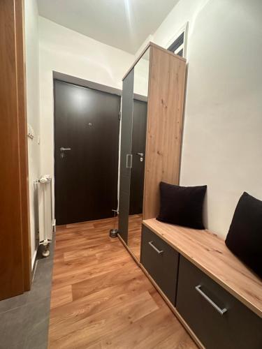 um quarto com um espelho e uma porta com um banco em Apartman Edita em Sarajevo
