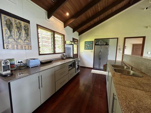 a large kitchen with white cabinets and a sink at Latui Lodge in Savusavu