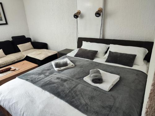 a bedroom with a large bed with towels on it at Milano Apartman **** in Brzeće