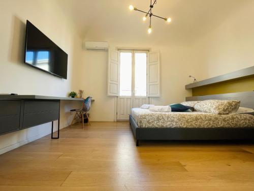 1 dormitorio con 1 cama y TV de pantalla plana en Dimora del Mercante en Catania