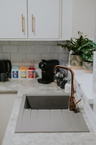 a kitchen sink with a faucet on a counter at BlueSeaView Apartment with fabulous sea views in Newcastle
