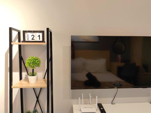 a bedroom with a bed and a clock on a shelf at K Avenue Modern Style Studio (5 Mins to Airport) in Kota Kinabalu