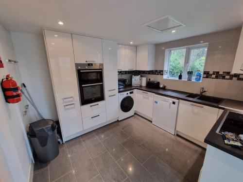 a kitchen with white cabinets and a dishwasher at Bridge House Sleeps 10 max in York, Free Parking in York