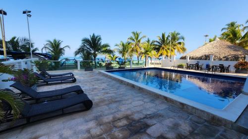 - une piscine avec des chaises longues et un complexe dans l'établissement Hermoso Apartamento frente al mar, 4 habitaciones - Apto 801, à Coveñas