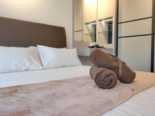 a bed with a stuffed animal on top of it at K Avenue Modern Style Studio (5 Mins to Airport) in Kota Kinabalu