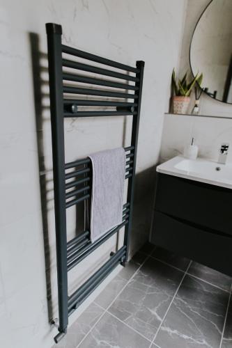 a bathroom with a towel rack next to a sink at BlueSeaView Apartment with fabulous sea views in Newcastle