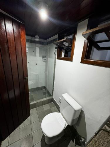 a bathroom with a toilet and a shower at Suíte na Passarela do Álcool in Porto Seguro