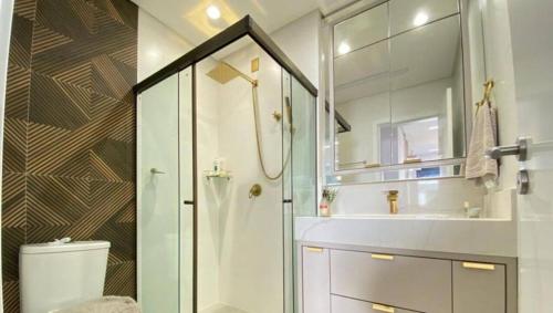 a bathroom with a shower and a toilet and a sink at Cobertura Palmas in Governador Celso Ramos