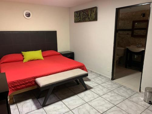 1 dormitorio con cama roja y almohada amarilla en Suites La Jolla, en Lima del Alto