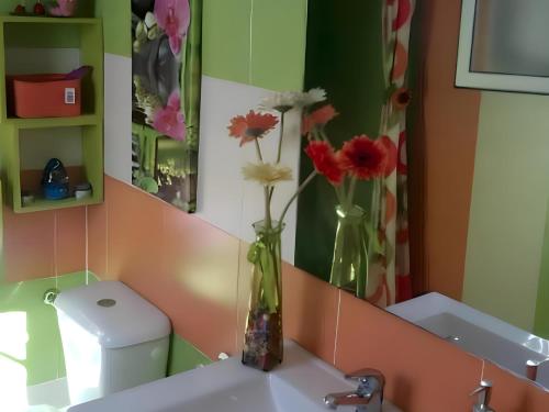 un baño con un jarrón con flores en un fregadero en Refugio Familiar Chalet Privado con Piscina Portátil para Familias y Parejas I, en Conil de la Frontera