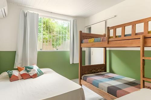 two bunk beds in a room with green walls at Sítio em Aldeia com piscina e lago in Camaragibe