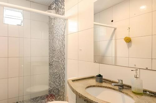 a bathroom with a sink and a mirror at Sítio em Aldeia com piscina e lago in Camaragibe