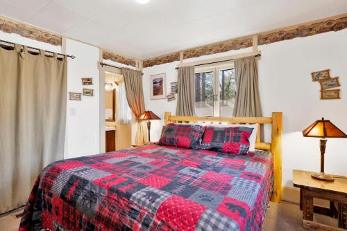 a bedroom with a bed with a red and black quilt at Lodge House-Family Cabin with Pool Table by Big Bear Vacations in Big Bear Lake