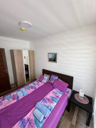 a bedroom with two beds with purple sheets at Apartmani Liman Kopaonik in Kopaonik