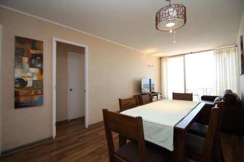 une salle à manger avec une table, des chaises et une fenêtre dans l'établissement Departamento Edificio Terrazas de Sol, à La Serena