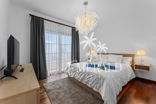 a bedroom with a large bed and a chandelier at Casa del Mar - Piscina y Jacuzzi Privado in Costa Teguise