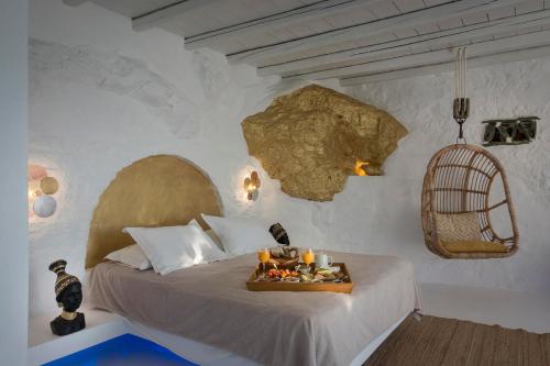 a bedroom with a bed with a tray of food on it at Onar Suites & Villas in Karavostasi