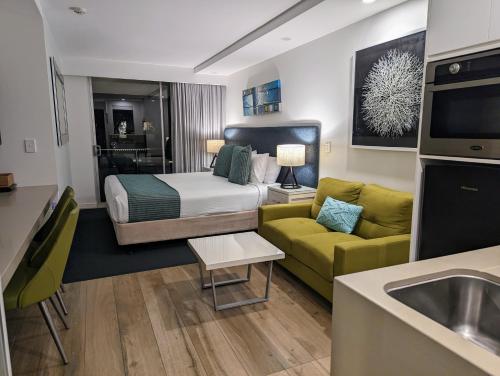 um quarto de hotel com uma cama e um sofá em Wantima Hastings St Studio em Noosa Heads