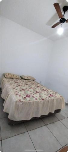 uma cama num quarto com uma ventoinha de tecto em Casa em Holambra- Sp em Holambra