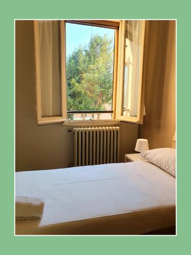 Un dormitorio con una cama grande y una ventana en Hotel Cavezzo, en Cavezzo