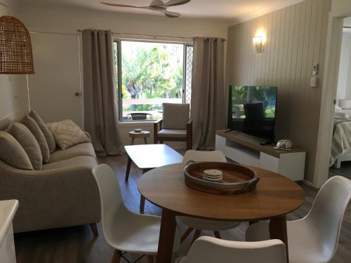 uma sala de estar com um sofá e uma mesa em Seabreeze at Silver Sands Hervey Bay em Hervey Bay