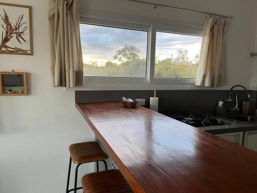 a kitchen with a wooden counter top and a window at Casa na Montanha (Mucugê/Bahia) in Mucugê