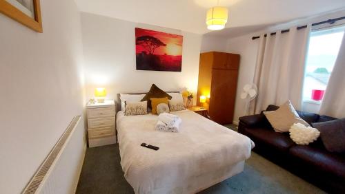 a small bedroom with a bed and a couch at Central Haven-5bedroom Great For Longer Stays In Canterbury kent!!! in Kent