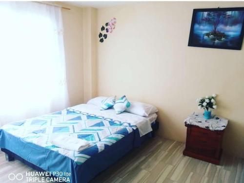 um quarto com uma cama com lençóis azuis e brancos em CASA DE LINDA em Baños