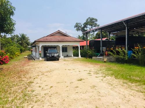 um edifício com um carro estacionado fora dele em House By the Palms em Kampong Sungai Rambai