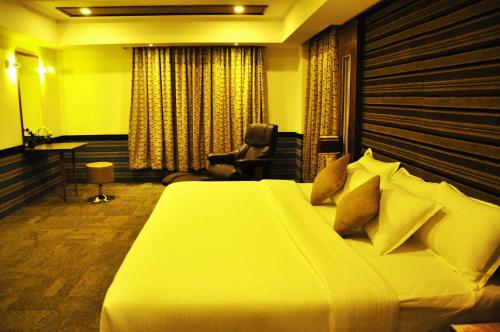 a bedroom with a large bed in a room at Hotel Atrium in Erode