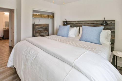 - une chambre avec un grand lit blanc et des oreillers bleus dans l'établissement Oxford Rebelville Walk to Campus & Square, à Oxford