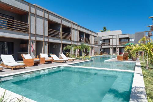 - une piscine en face d'un bâtiment avec des chaises longues dans l'établissement TOCA GAMBOA, à Porto de Pedras
