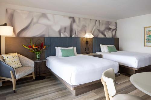 une chambre d'hôtel avec deux lits et une chaise dans l'établissement The Royal Sonesta Kauai Resort Lihue, à Lihue
