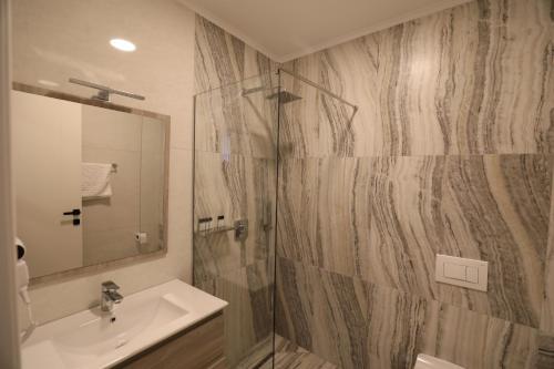 La salle de bains est pourvue d'un lavabo et d'une douche. dans l'établissement Dallga Suites, à Tushemisht
