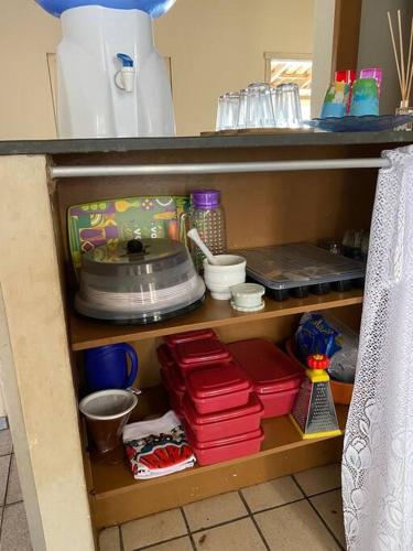 uma prateleira com pratos e outros itens numa cozinha em Casa com terraço em Piúma. em Piúma