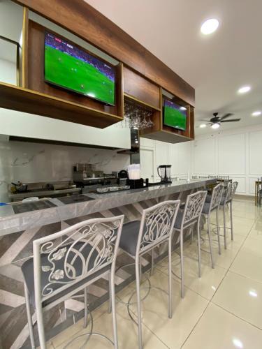 a bar with a row of chairs and televisions at Hotel Patrimonial by Greenfield in Guayaquil